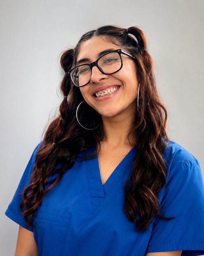 Portrait of Monique Flores in blue scrubs.